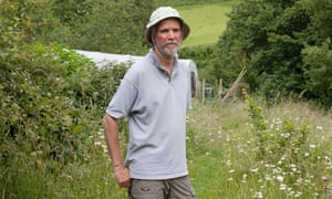 Chris Higgins, part of a small collective of volunteers that plant and grow edible crops, stands in the grounds of a plant garden in Machynlleth, north Wales.