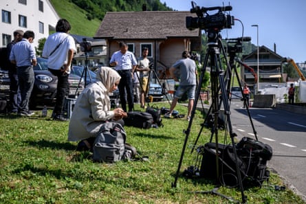 A group of journalists next to cameras on tripods in a Swiss village