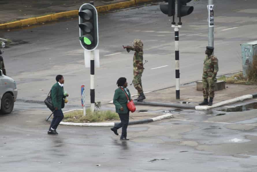 Armed soldiers stand on the road leading to President Robert Mugabe’s office in Harare.