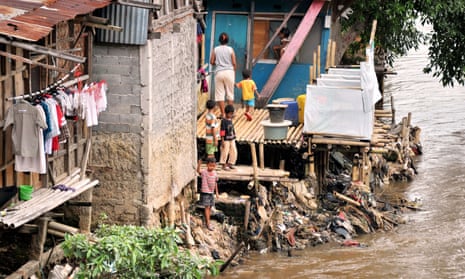 Children fish on a river bank in one of downtown Jakarta’s slum areas next to public toilets.