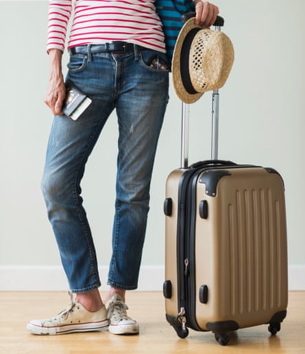 A woman with a hat, suitcase and travel documents ready to go on holiday