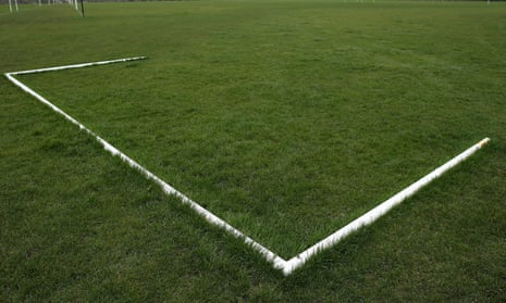 A set of goalposts on the turf of a pitch used for amateur football.
