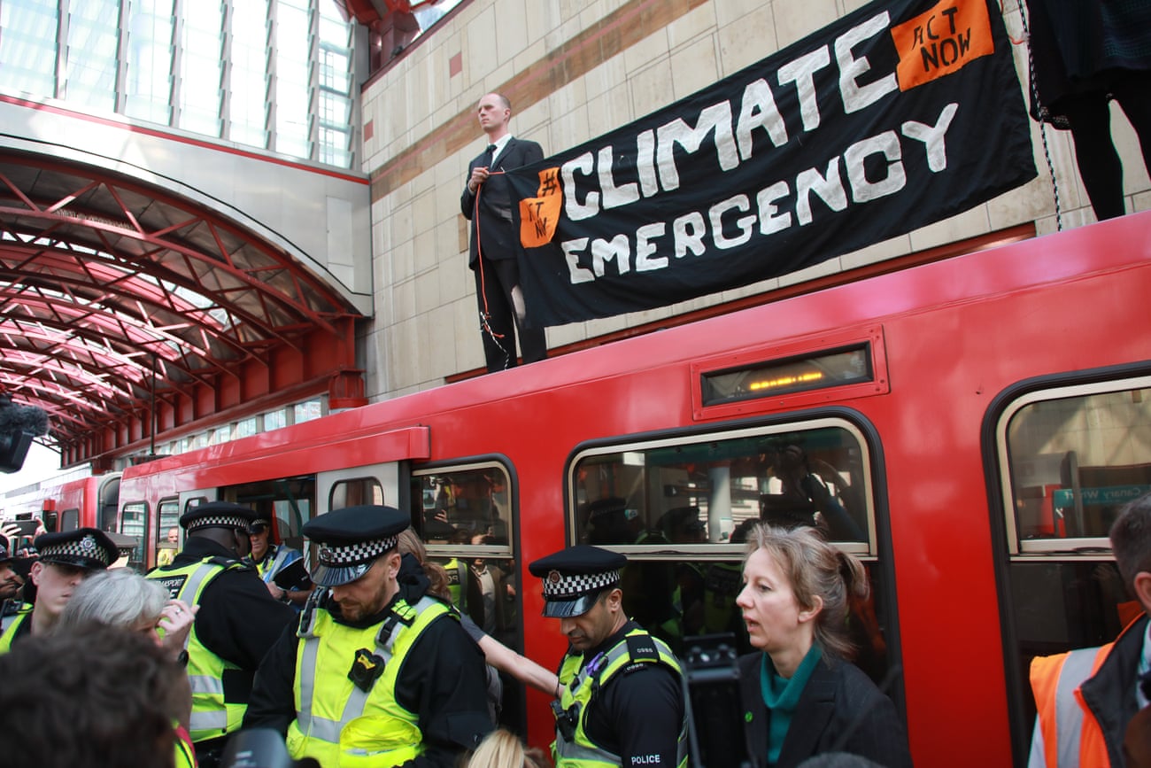 Activists climb on top of a DLR train at Canary Wharf in April