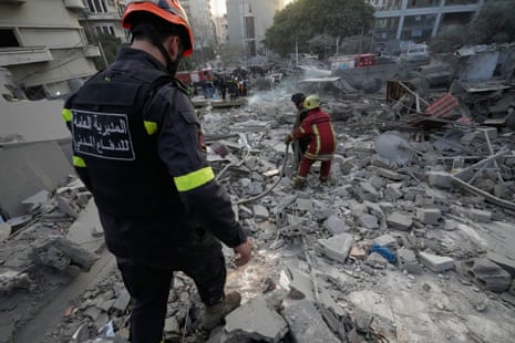 Rescue workers check a building that was destroyed by an Israeli strike in central Beirut, Lebanon