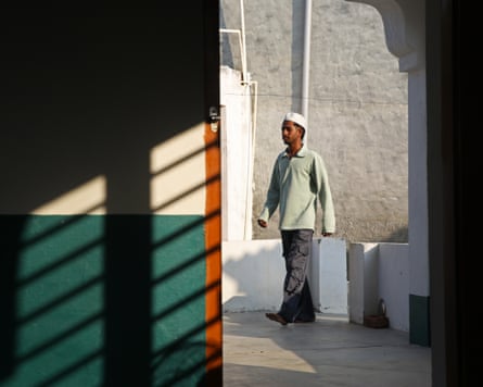 Young man in a white cap walks into a mosque in Punjab for evening prayers