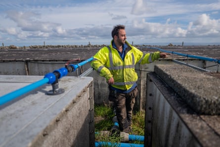 Tristan Howes points as he stands in water infrastructure.
