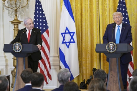 two men wearing suits stand behind separate podiums