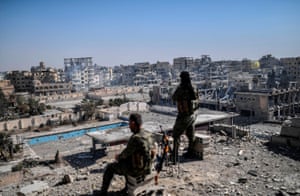 Raqa, 2017 Fighters from the Syrian Democratic Forces stand guard on a rooftop