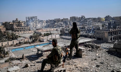 Syrian Democratic Forces fighters stand guard in Raqqa on 20 October after retaking the city from Isis militants. 