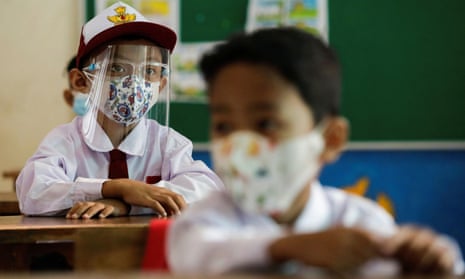 Elementary school students wearing face masks and face shields attend class in Jakarta