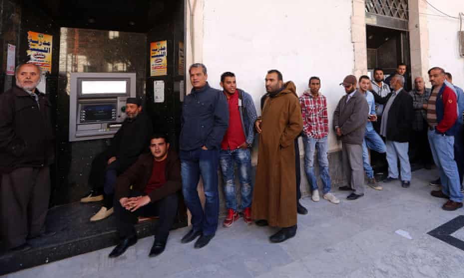 Libyans wait to withdraw money from an ATM machine outside a bank in the capital Tripoli.