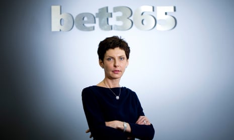 A woman stands in front of a wall with the bet365 logo