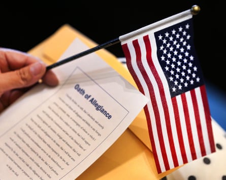 A woman holds an American flag during a naturalization ceremony.