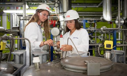Students in overalls and hard hats at work on a carbon capture project in the department of chemical engineering.