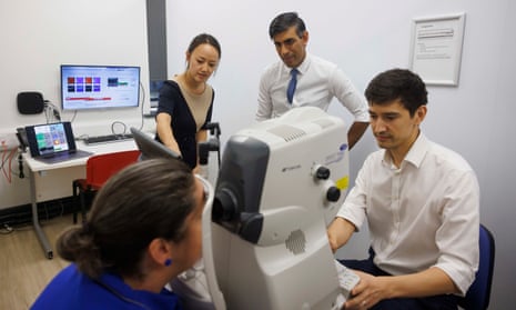 Research team member Polly Rawlinson has a retinal scan procedure performed by Dr Siegfried Wagner as Rishi Sunak and Dr Xiao Liu watch.