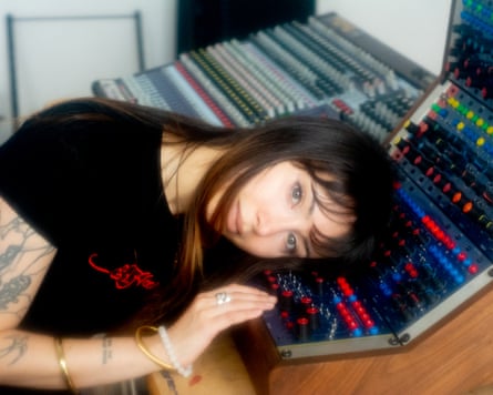 Wallis resting her head on a sound production machine with brightly coloured buttons
