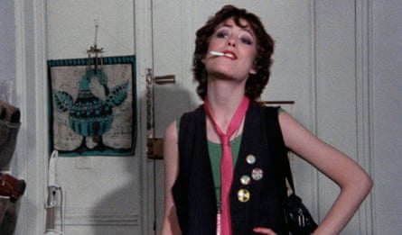 a woman standing with a cigarette in her mouth