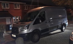 A silver ford transit cargo van parked outside a house.