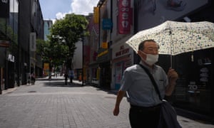 Un hombre mayor con una máscara facial camina por una calle vacía en el distrito comercial Myeongdong de Seúl el 25 de agosto.