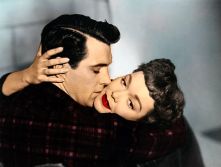 A man and a woman - with 1950s hairstyles and the woman with bright red lipstick - locked in a passionately embrace, with the woman looking off to the side