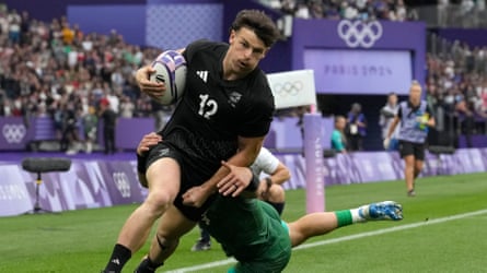 Leroy Carter being tackled while running holding a rugby ball