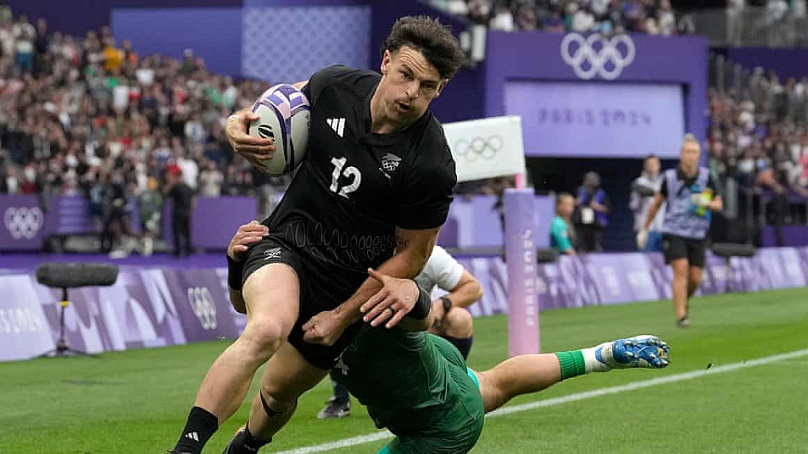 Leroy Carter being tackled while running holding a rugby ball