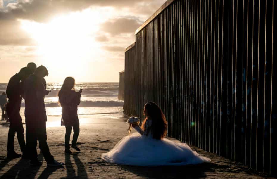 A girl celebrating turning 15 poses beside the border fence in Playas de Tijuana, Baja California, Mexico, 27 September