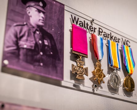 Medals on a wall display in an exhibition alongside picture of Parker