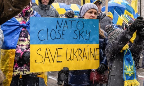 Anti-war protester holds up a sign saying Nato close sky. Save Ukraine.