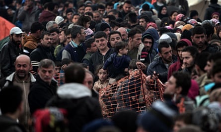 Refugees and migrants queue for food at the Greek-Macedonian border on Friday.