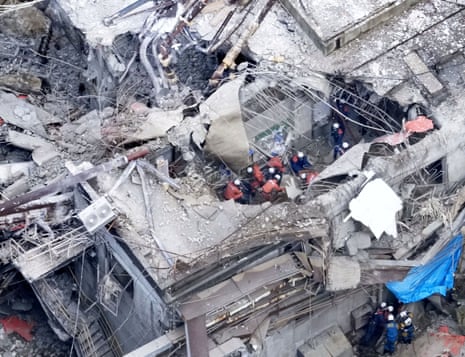 Rescue workers searching through the rubble of a damaged building.