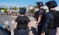 Police keep watch as people queue to enter a supermarket to purchase groceries and food in the Magenta district of Noumea, France's Pacific territory of New Caledonia.