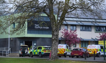 Ambulance and police cars parked outside the front of the Amman Valley school building