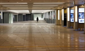Eerie ... a woman wearing a protective face mask walks in an empty underpass near Tokyo Station in Tokyo, Japan