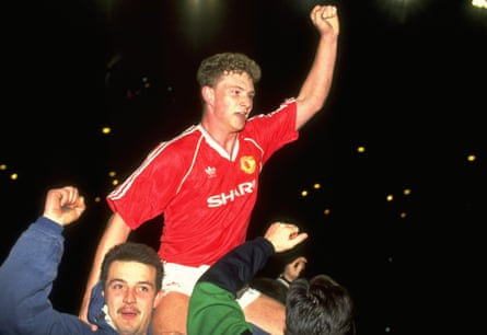 Mark Robins is hoisted on the shoulders of Manchester United fans in 1990.