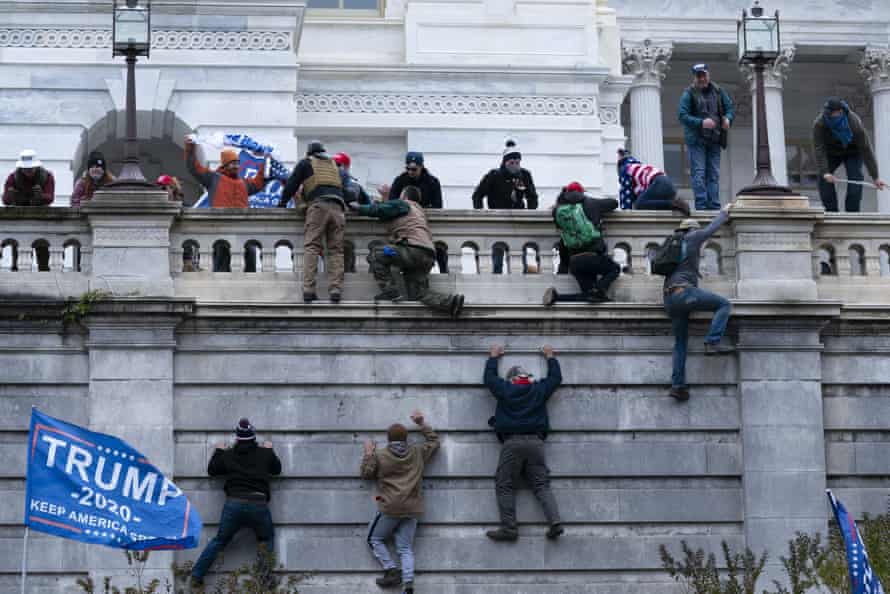 Trump supporters climb the west wall of the Capitol.
