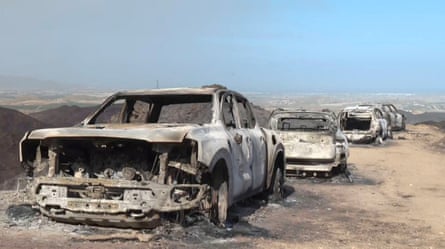 A line of burnt-out cars on a road