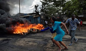 A woman leads a boy away from violence in Kibera.