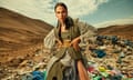Model dressed in clothes salvaged from waste fashion poses at a vast dump in the desert