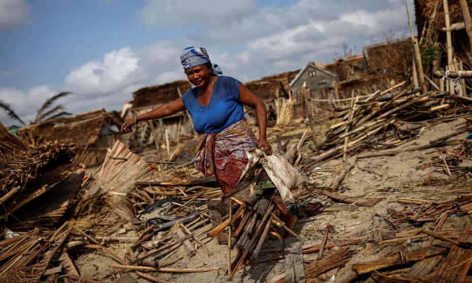 A woman carries pieces of wood in the aftermath of Cyclone Batsirai in the town of Mananjary, Madagascar