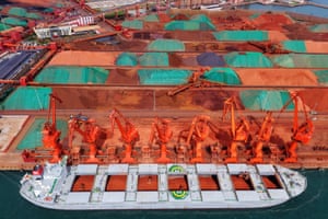 A row of huge orange cranes at work