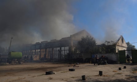 Smoke rises from warehouses in the aftermath of a Russian military strike in Kherson