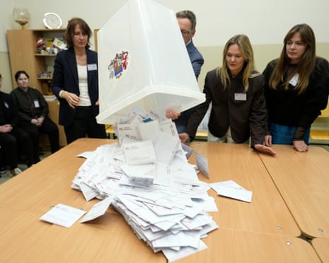 Election district officials open a ballot box during the general election in Riga, Latvia.