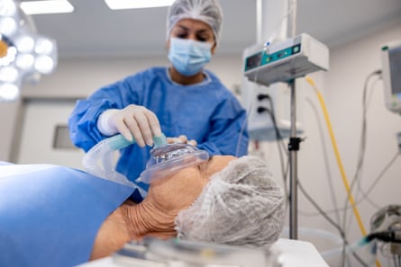 Anaesthetist putting an oxygen mask on a patient under anesthesia in the hospital - operating room