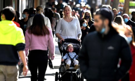 A mother and baby walking down a crowded street in Melbourne, Australia