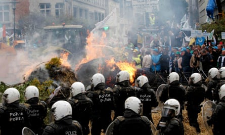 Belgian riot police stand guard as farmers protest