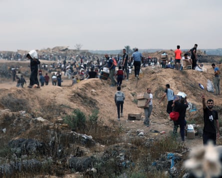 Palestinians walk with aid supplies