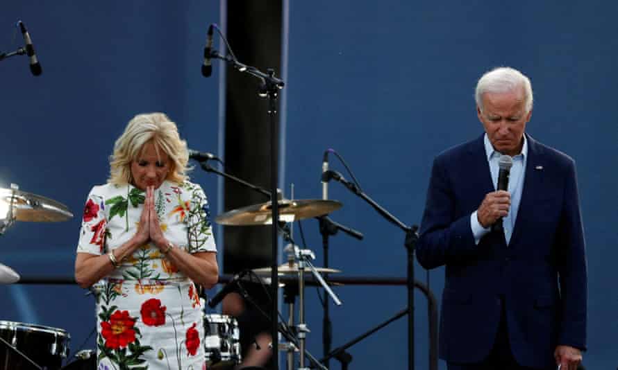 Bidens stand looking downward; Jill holds hands in prayer