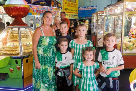 Five children and their mother, dressed mainly in green, in an amusement arcade in England in 2023