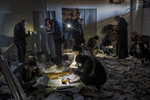People look at documents on the floor inside the Sednaya prison